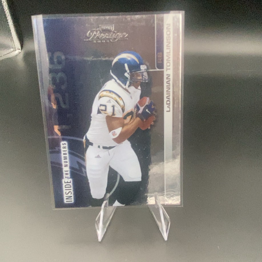 2006 Prestige LaDainian Tomlinson: This is a 2006 Prestige trading card featuring running back LaDainian Tomlinson of the San Diego Chargers. The card is part of the 'Inside The Numbers' insert series, as indicated by the text on the