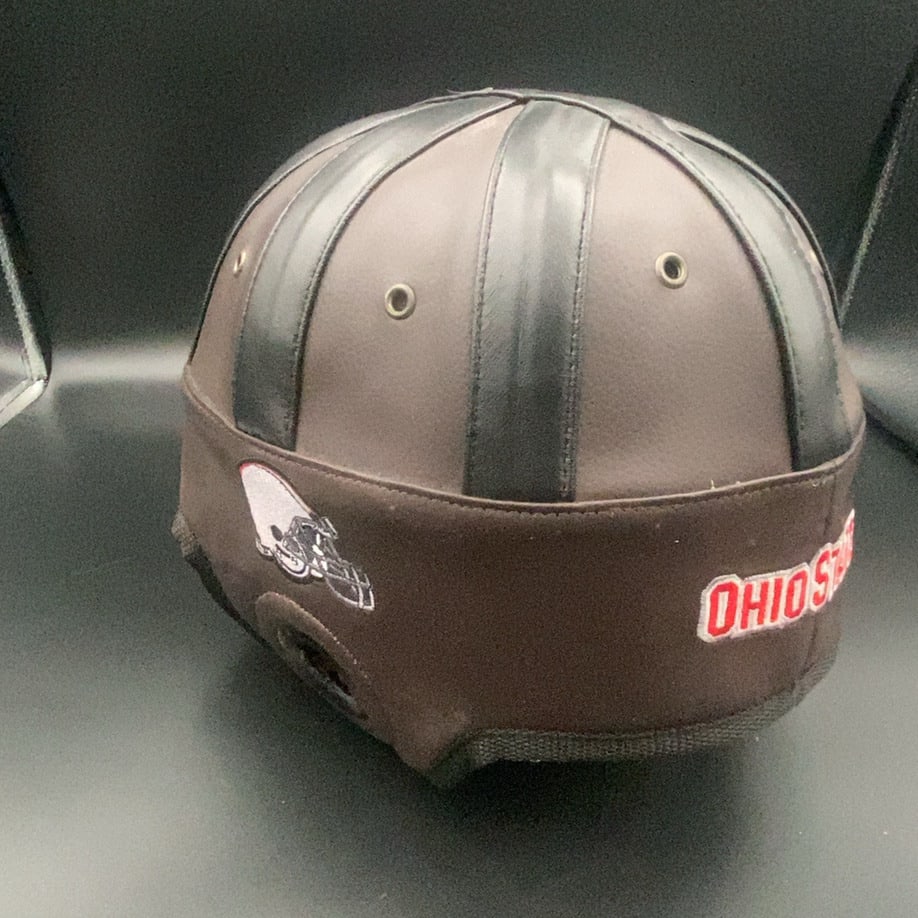 Ohio State Football Leather Helmet: This is a vintage-style leather football helmet featuring the Ohio State University team name embroidered on the side. The helmet includes a small graphic representation of a football helmet and
