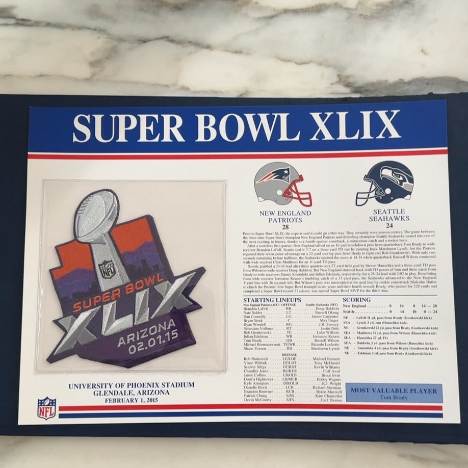 Super Bowl XLIX Commemorative Plaque: This is a commemorative plaque celebrating Super Bowl XLIX, held on February 1, 2015, at the University of Phoenix Stadium in Glendale, Arizona. It features an embroidered patch of the Super Bowl