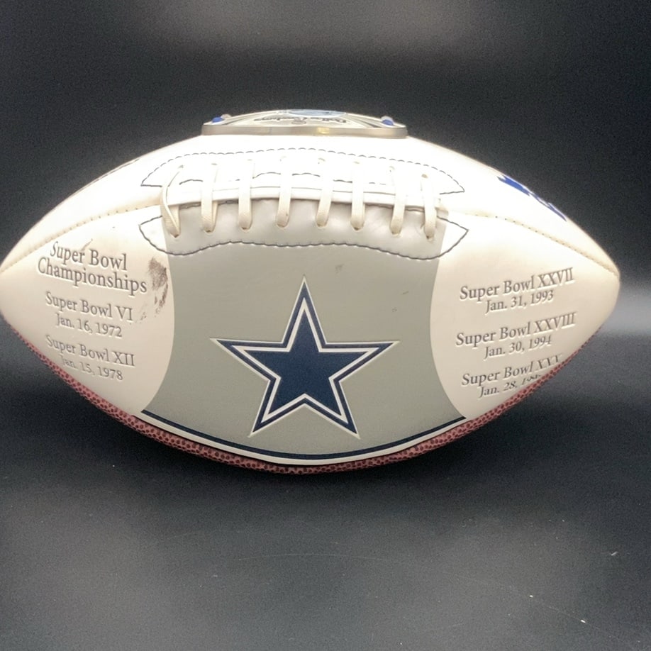 Dallas Cowboys Super Bowl Champions Commemorative Football: a commemorative Dallas Cowboys football featuring the team's iconic star logo. It lists several Super Bowl championships won by the team, including Super Bowls VI, XII, XXVII, XXVIII, and XXX. The