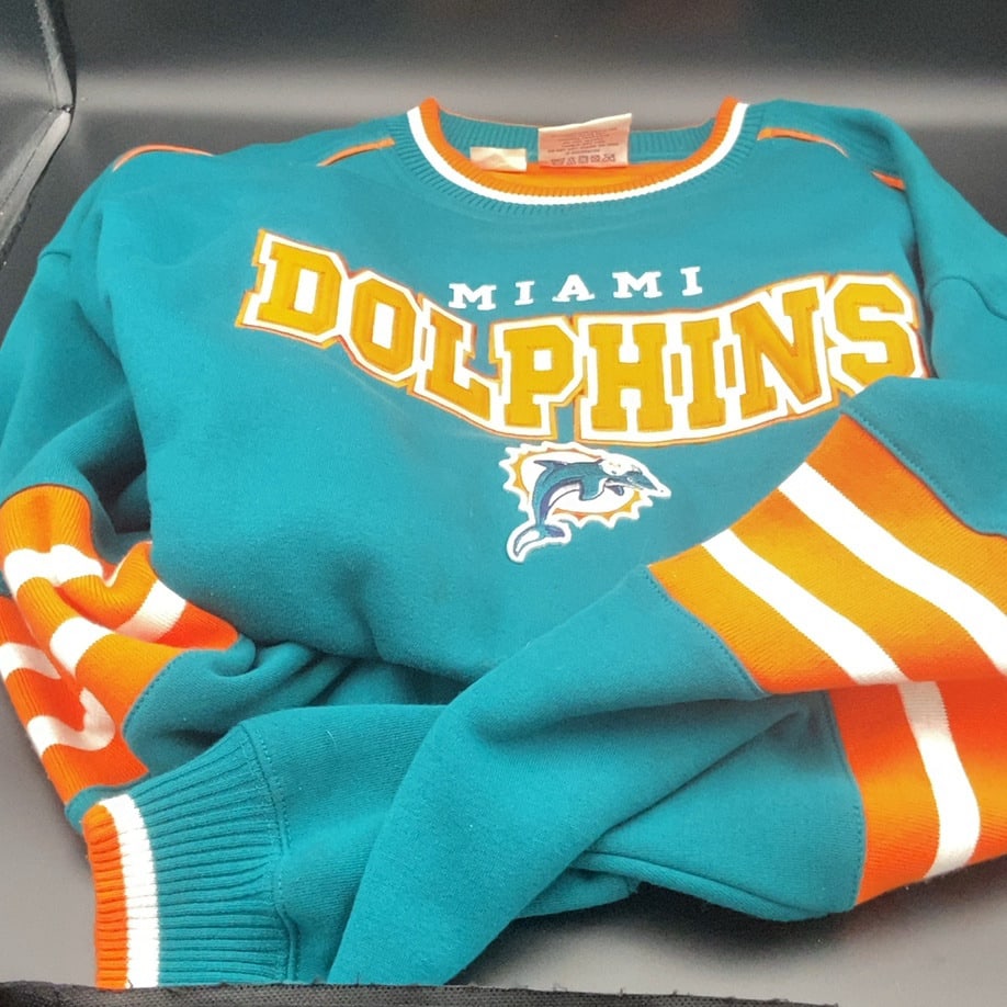 Miami Dolphins Vintage Sweatshirt: a vintage Miami Dolphins crewneck sweatshirt featuring the team's iconic teal and orange colors. The front prominently displays the Miami Dolphins wordmark in yellow text with the team logo emblem