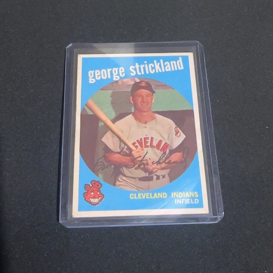1961 Topps George Strickland Baseball Card: This is a 1961 Topps baseball card featuring George Strickland of the Cleveland Indians. The card depicts Strickland in a portrait shot with a facsimile autograph and the iconic Chief Wahoo logo in th