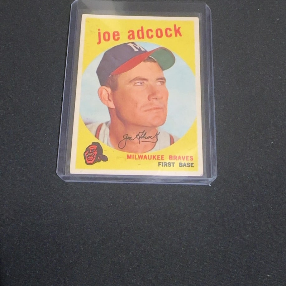 1957 Topps Joe Adcock Milwaukee Braves Baseball Card: This is a 1957 Topps baseball card featuring Milwaukee Braves first baseman Joe Adcock. The vintage card displays a classic portrait within a yellow background and includes his facsimile signature and