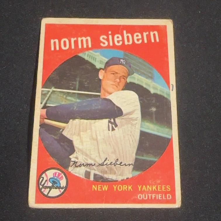Norm Siebern New York Yankees Baseball Card: This is a vintage baseball card featuring Norm Siebern as an outfielder for the New York Yankees. The card design features a round portrait of the player over a red background and includes the iconic