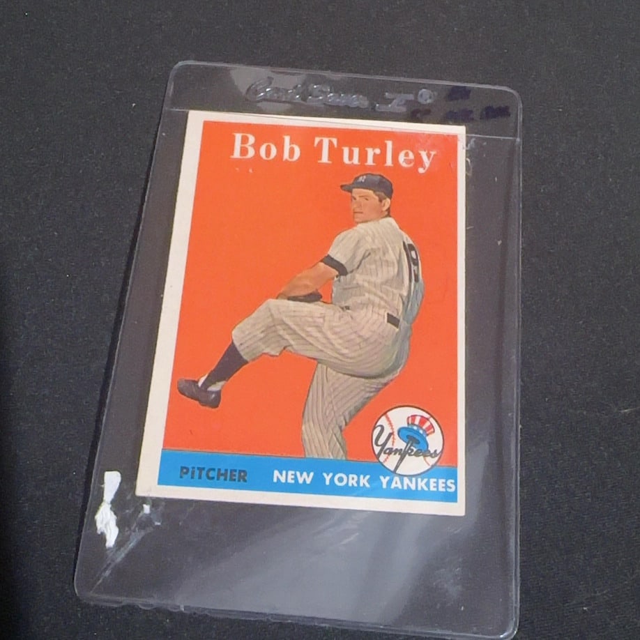 1958 Vintage Bob Turley New York Yankees Baseball Card: This is a vintage baseball card featuring New York Yankees pitcher Bob Turley. The card depicts him in his pitching motion on an orange background with a team graphic.