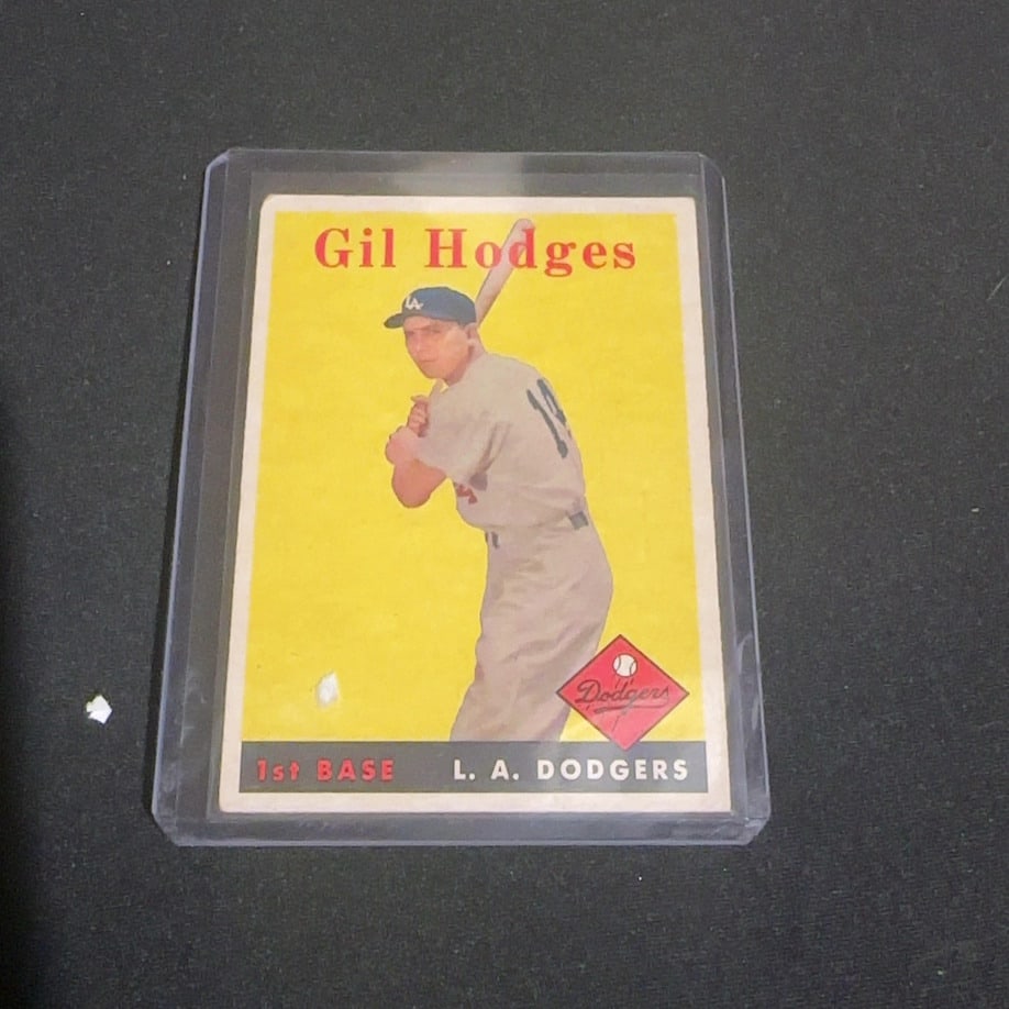 1958 Vintage Topps Gil Hodges Los Angeles Dodgers Baseball Card: This is a 1958 Vintage Topps baseball card featuring Gil Hodges of the Los Angeles Dodgers. The card shows Hodges in his batting stance against a vibrant yellow background and is protected in a hard p