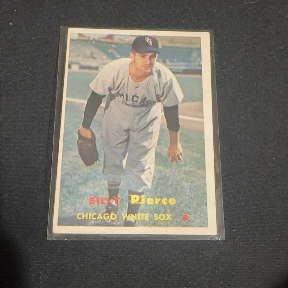 1957 Vintage Topps Billy Pierce Baseball Card: 1957 Vintage Topps baseball card featuring Chicago White Sox pitcher Billy Pierce. The card shows Pierce in his home uniform and is preserved in a plastic sleeve. It is a classic vintage sports collec