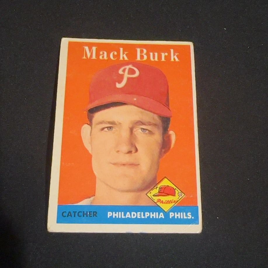 Mack Burk Philadelphia Phils: This is a vintage baseball card featuring Mack Burk of the Philadelphia Phils. The card identifies his position as Catcher and features a bold orange background with a team logo graphic.