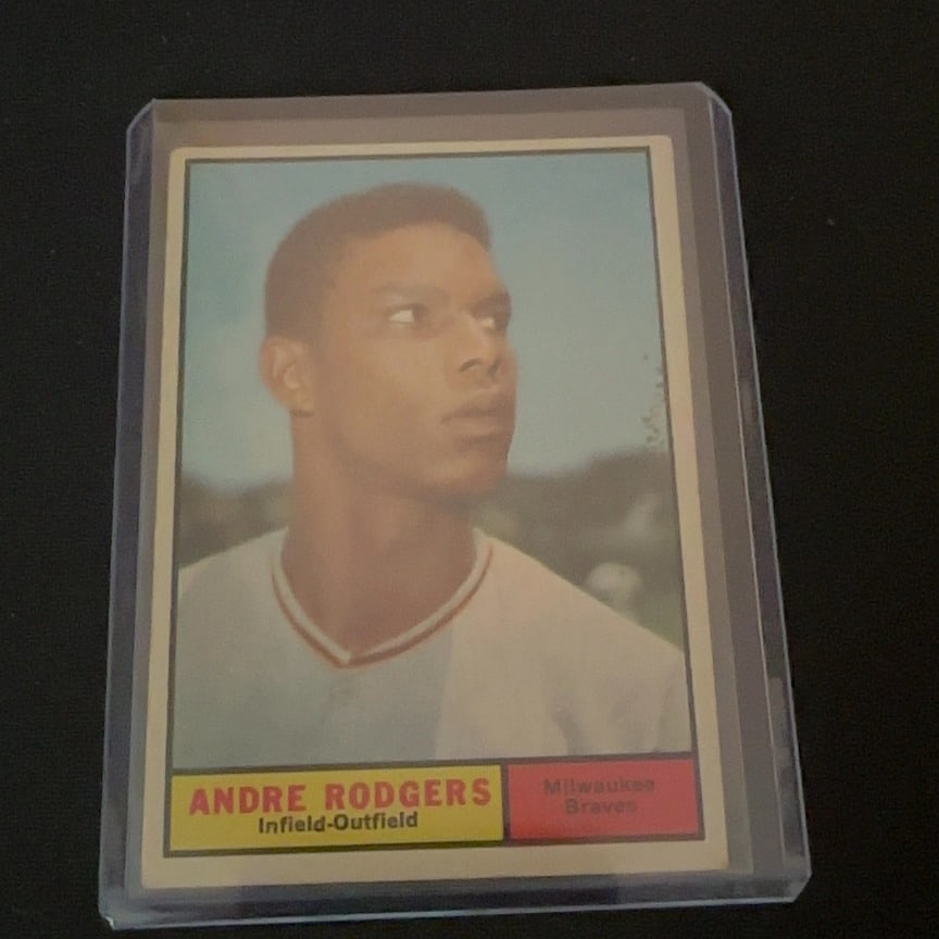 Andre Rodgers Milwaukee Braves: This is a vintage sports card featuring Andre Rodgers as a member of the Milwaukee Braves. He is listed as an Infield-Outfield player. The card design features a portrait-style headshot with the team