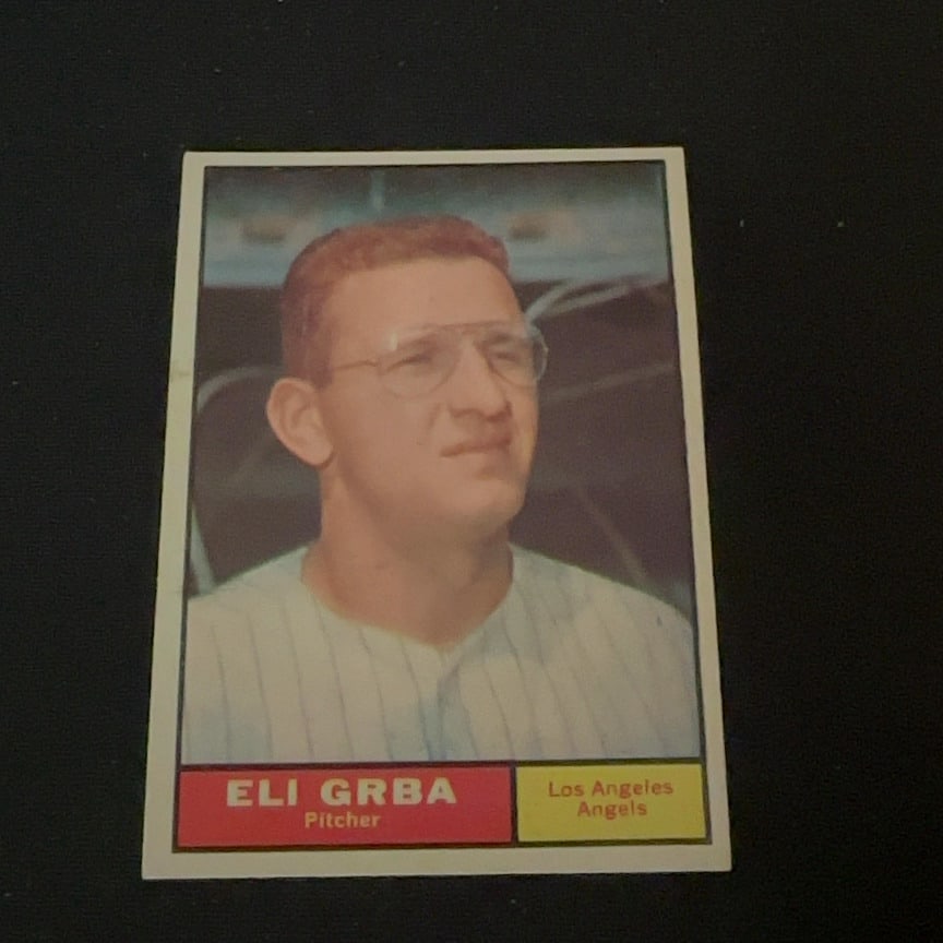 1961 Topps Eli Grba Los Angeles Angels Card: This is a 1961 Topps baseball card featuring pitcher Eli Grba of the Los Angeles Angels. The card captures a head-and-shoulders portrait of the player wearing his team uniform and glasses.