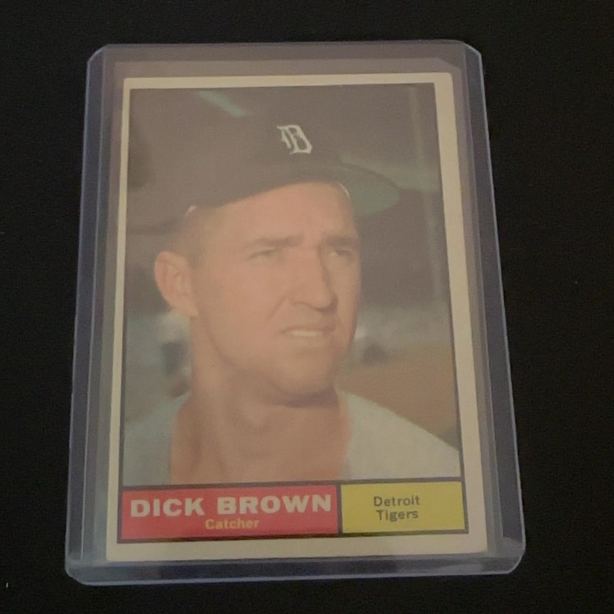 1961 Topps Dick Brown: 1961 Topps baseball card featuring Dick Brown, who is identified as a catcher for the Detroit Tigers. The card features a portrait of the player wearing a Detroit Tigers cap.