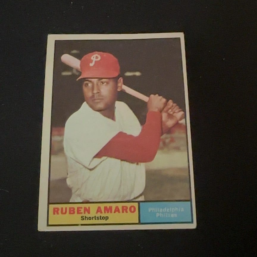 Vintage Ruben Amaro Philadelphia Phillies Baseball Card: This is a vintage sports card featuring Philadelphia Phillies shortstop Ruben Amaro. It shows him holding a bat, wearing his team uniform and cap. The card design includes a yellow name bar and blue t
