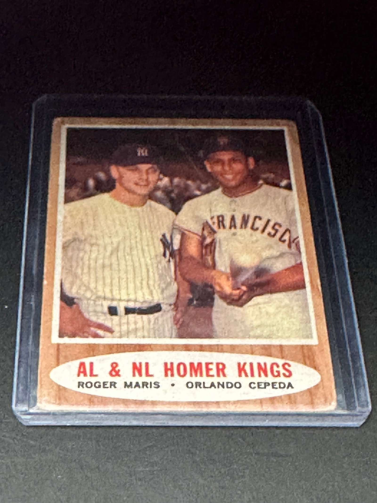 AL & NL Homer Kings Roger Maris Orlando Cepeda: This is a 1962 Topps baseball card titled AL & NL Homer Kings. The card features MLB players Roger Maris and Orlando Cepeda. It is housed in a protective plastic sleeve.