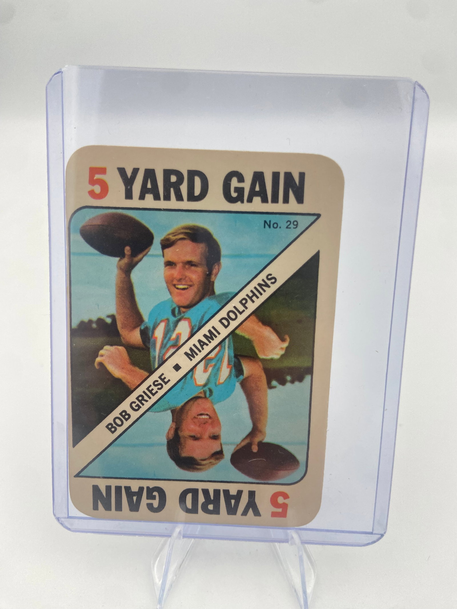Bob Griese Miami Dolphins 5 Yard Gain: This is a vintage sports card featuring Miami Dolphins quarterback Bob Griese. The card is labeled '5 YARD GAIN' and features card number 29. It depicts Griese in his team jersey holding a football.