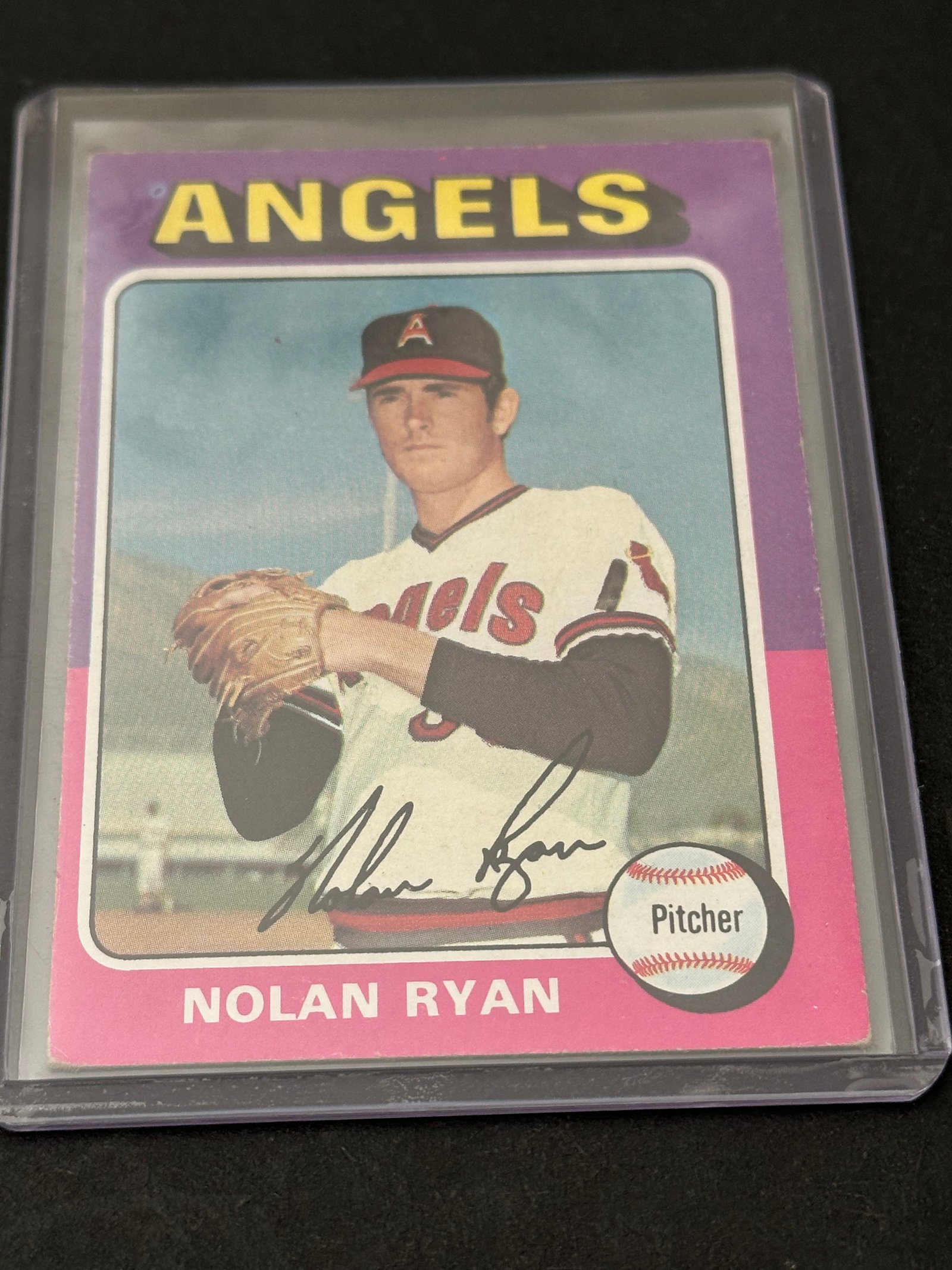 1975 Topps Nolan Ryan: This is a 1975 Topps baseball card featuring Nolan Ryan of the California Angels. The card includes a printed signature and a graphic of a baseball labeled Pitcher.