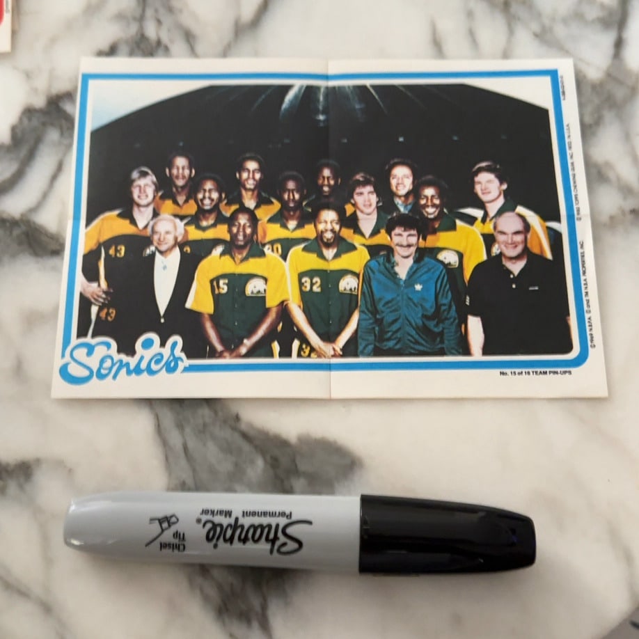 1980 Topps Seattle SuperSonics Team Pin-Ups: This is a 1980 Topps Seattle SuperSonics team pin-up, identified as card number 15 of 16 in the set. The item features a group photograph of the team players and staff, with the Sonics logo printed