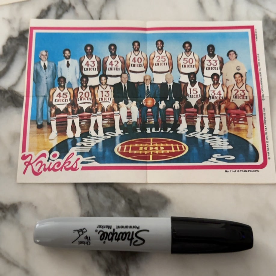 1980 Topps New York Knicks Team Pin-Up: This is a 1980 Topps NBA team pin-up poster featuring the New York Knicks basketball team. It includes a group portrait of players and staff on the court at Madison Square Garden. This item is labeled