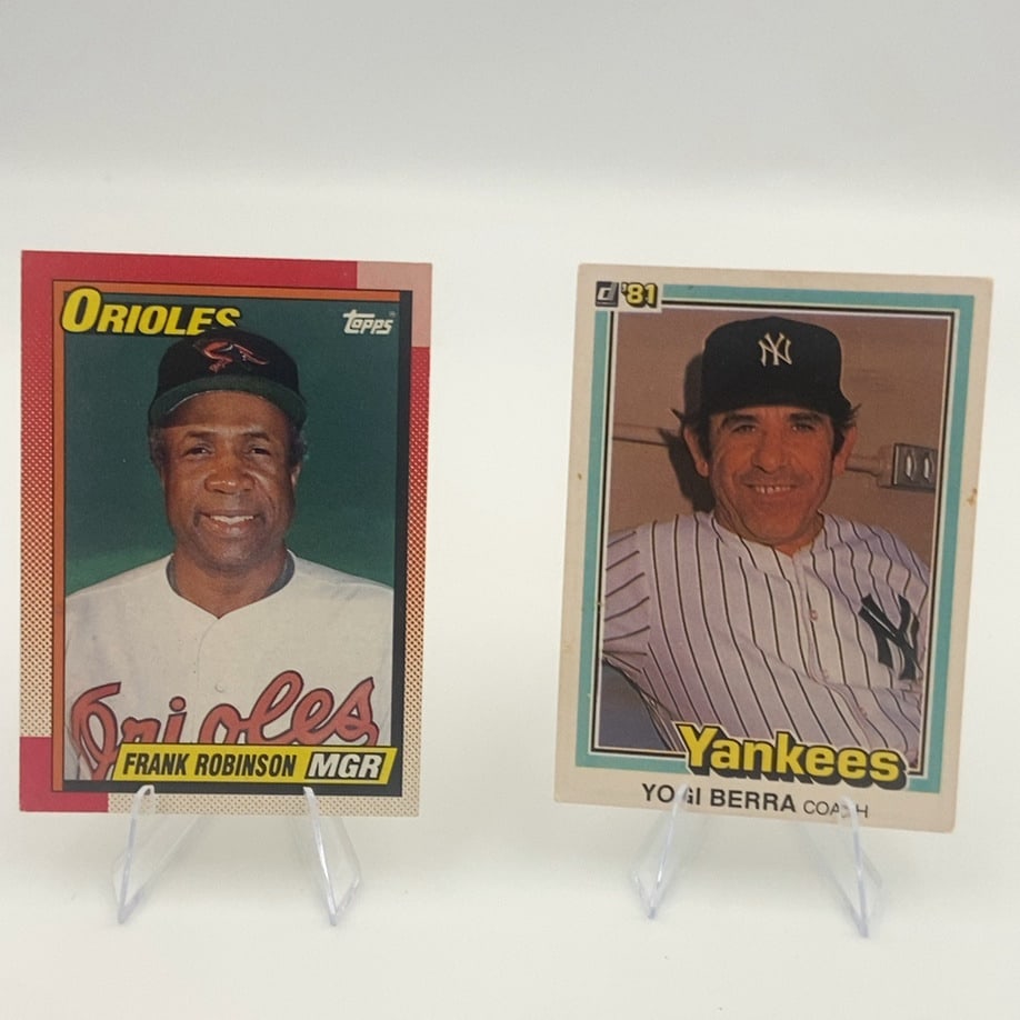 1981 Topps Frank Robinson and 1981 Donruss Yogi Berra: This lot features two vintage baseball cards from 1981. One is a Topps card featuring Orioles manager Frank Robinson, and the other is a Donruss card featuring Yankees coach Yogi Berra.