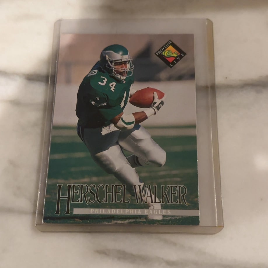 1992 Pro Line Live Herschel Walker Philadelphia Eagles: This is a 1992 Pro Line Live football card featuring Herschel Walker of the Philadelphia Eagles. The card is encased in a protective plastic sleeve and appears to be in good condition. It showcases