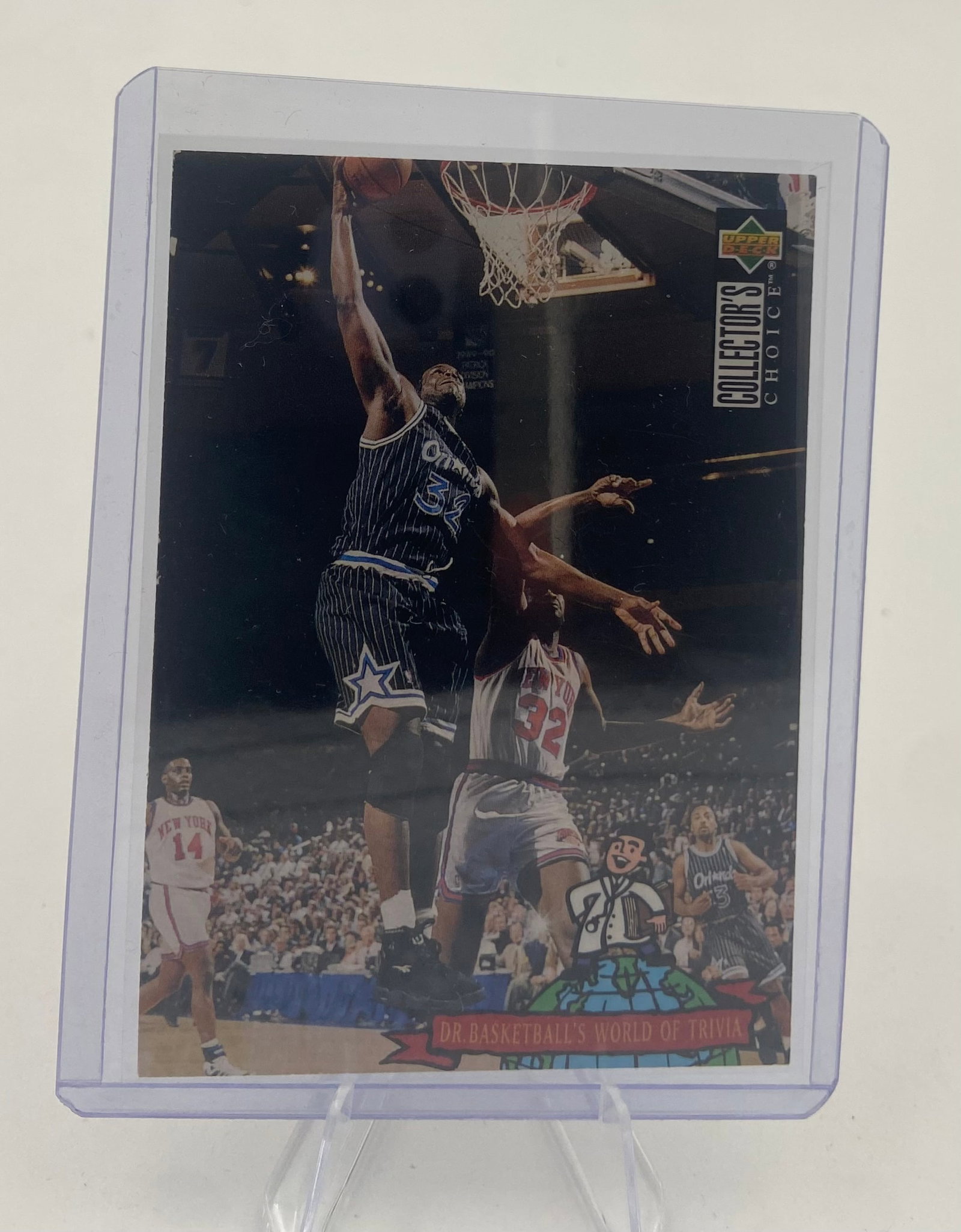 1994-95 Upper Deck Collector's Choice Shaquille O'Neal: This is a 1994-95 Upper Deck Collector's Choice trading card featuring Shaquille O'Neal. The card captures a dynamic action shot of O'Neal dunking against the New York Knicks. It includes the Dr.