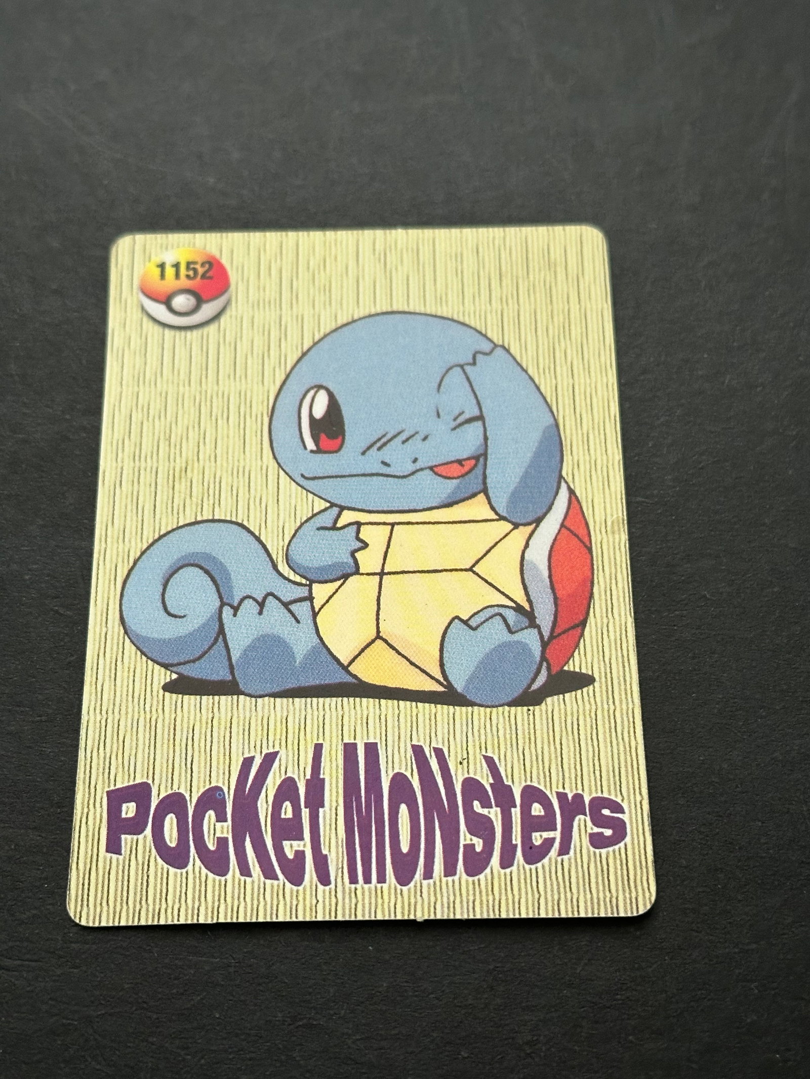 Pocket Monsters Squirtle Card: This is a collectible trading card featuring the Pokémon Squirtle. The card displays the 'Pocket Monsters' logo vertically on the right side and the number 1152 inside a Poké Ball emblem.