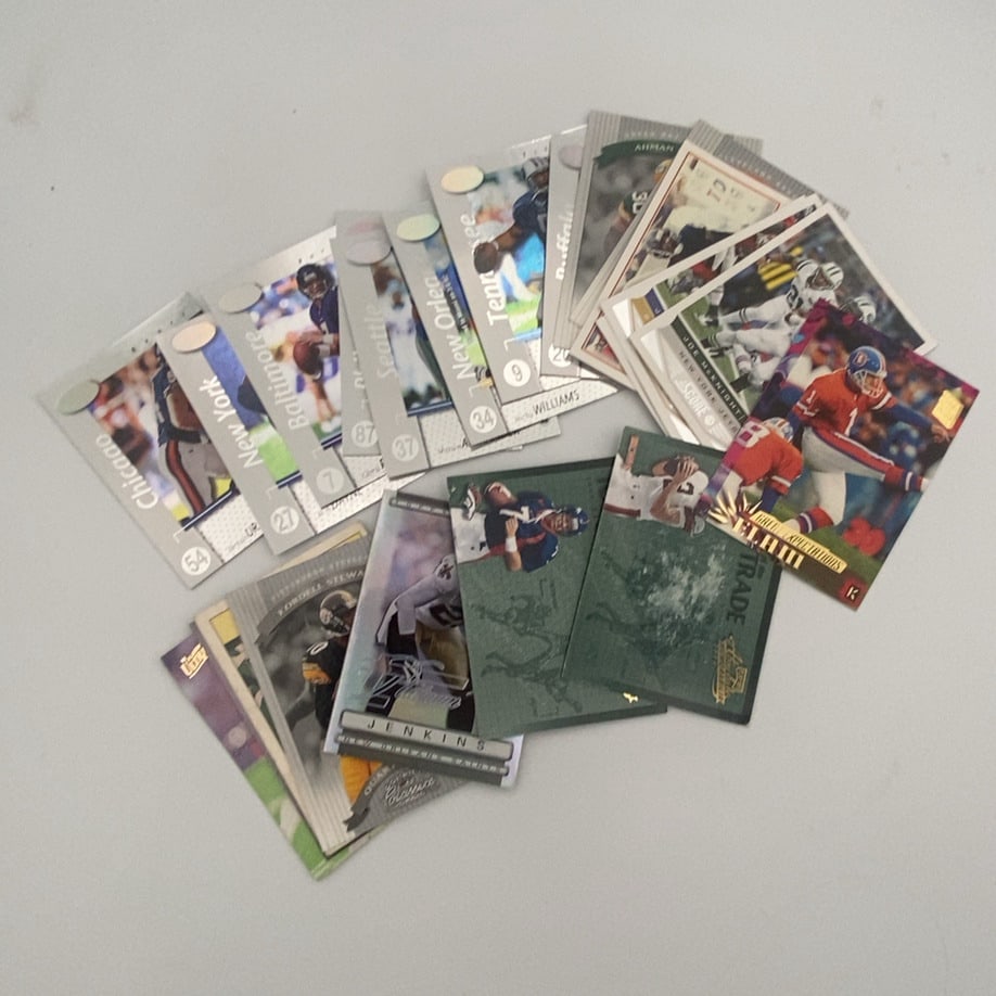 Assorted Football Trading Cards Lot: This is a collection of various football trading cards featuring multiple teams and players. Several major sports card brands are visible within this assorted lot of memorabilia.