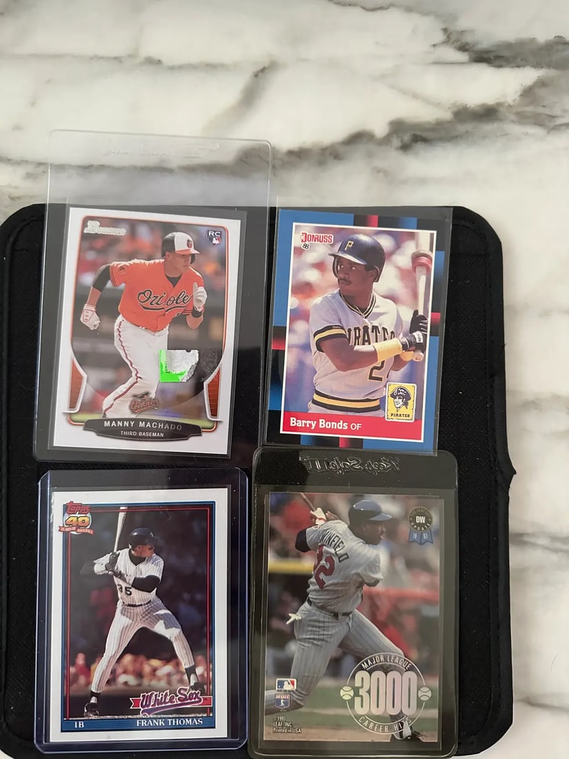 Assorted Baseball Trading Card Lot: A collection of four baseball cards featuring Manny Machado, Barry Bonds, Frank Thomas, and a Dave Winfield 3000 career hits commemorative card. The cards represent various manufacturers including Bow