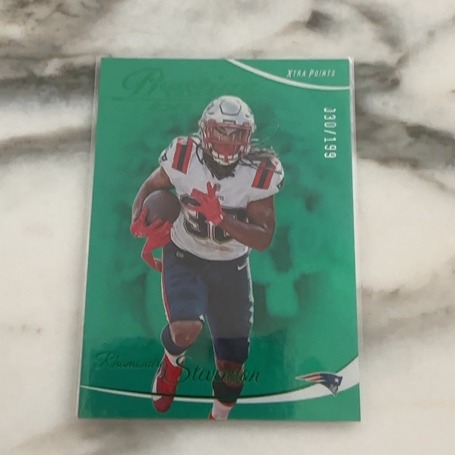 2021 Panini Prestige Rhamondre Stevenson Xtra Points Green: This is a 2021 Panini Prestige Xtra Points Green parallel trading card featuring New England Patriots running back Rhamondre Stevenson. The card is serial-numbered 030/199 and appears to be in raw,