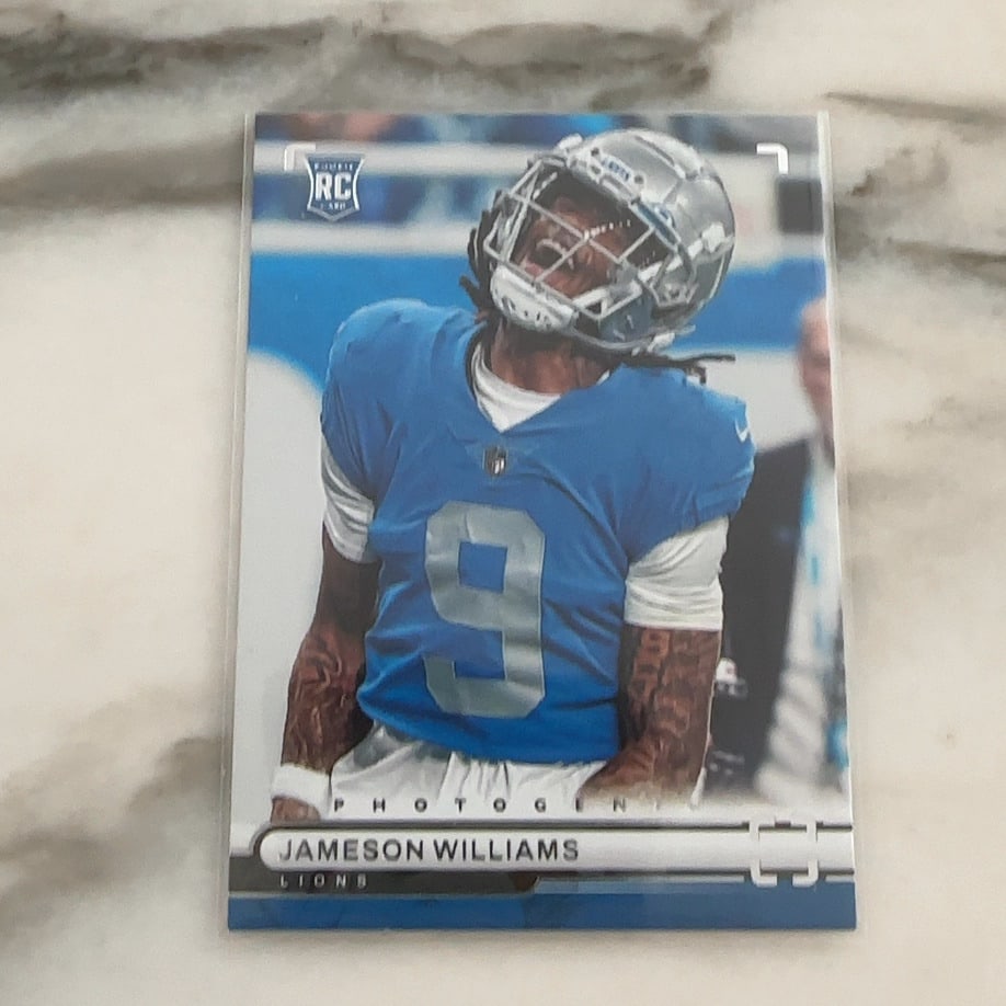 2022 Panini Photogenic Jameson Williams Rookie Card: This is a 2022 Panini Photogenic Rookie Card featuring Detroit Lions wide receiver Jameson Williams. The card is in excellent raw condition and features the iconic Rookie Card (RC) logo prominently
