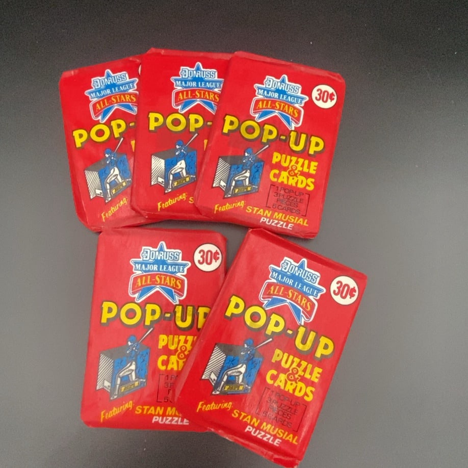 Donruss Major League All-Stars Pop-Up Puzzle & Cards: A collection of five unopened Donruss Major League All-Stars Pop-Up Puzzle & Cards wax packs. Each pack is priced at 30 cents and features a Stan Musial puzzle component.