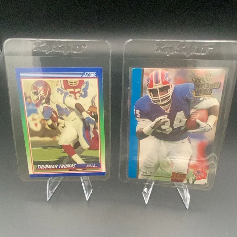 Thurman Thomas Score and Madden Team Cards: This image displays two football trading cards featuring Buffalo Bills running back Thurman Thomas. One card is from the Score brand, while the other card features the 'The All Madden Team' design