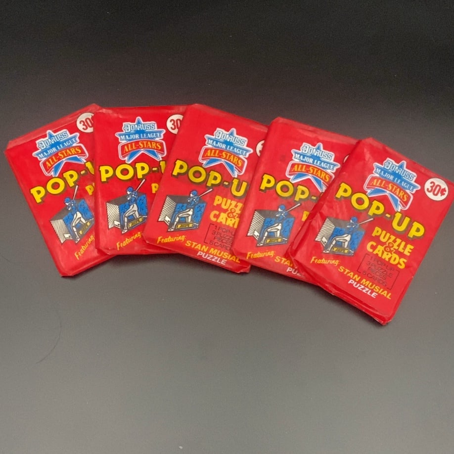 Donruss Major League All-Stars Pop-Up Puzzle & Cards: lot features five unopened packs of 1980s Donruss Major League All-Stars Pop-Up Puzzle & Cards. Each red wax pack features Hall of Famer Stan Musial and contains one pop-up, three puzzle pieces, and