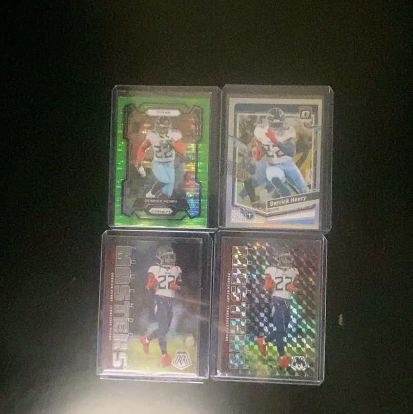 Derrick Henry Trading Cards Lot: This lot includes four individual Derrick Henry football cards, featuring various Panini designs including Prizm, Optic, and Mosaic. Each card displays Derrick Henry in his Tennessee Titans uniform.