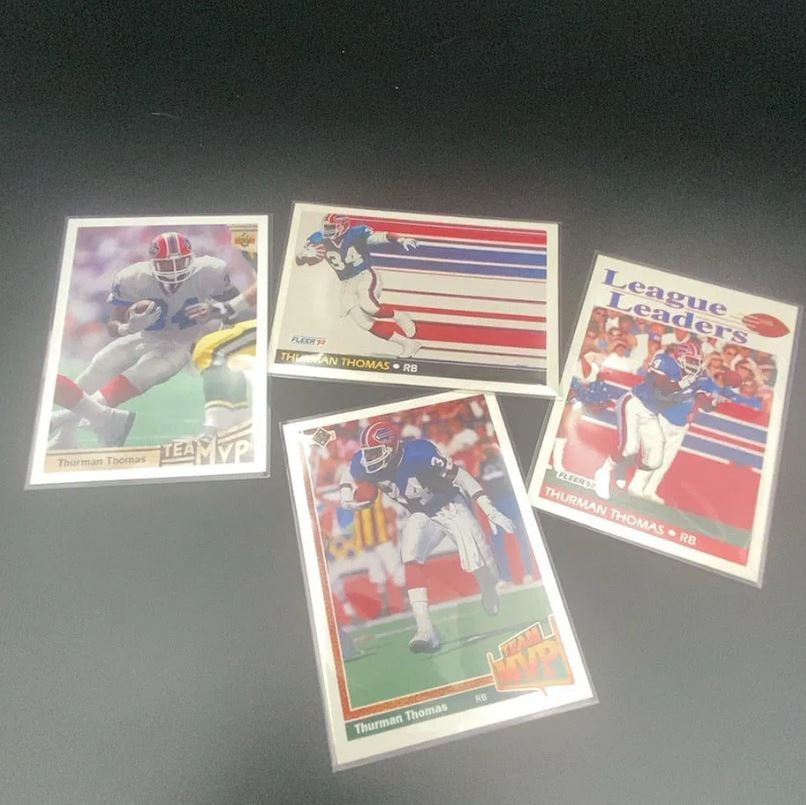 1992 Fleer and Upper Deck Thurman Thomas Cards: This lot features a collection of four football trading cards depicting Thurman Thomas. The cards include 1992 Fleer 'League Leaders' and standard Fleer editions, alongside Upper Deck 'Team MVP'