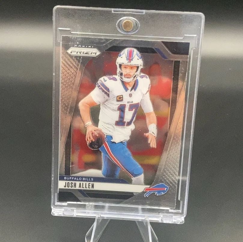 Panini Prizm Josh Allen: This is a Panini Prizm football card featuring Buffalo Bills quarterback Josh Allen. The card displays him in his white game uniform, and it is preserved in a clear magnetic protective case. The