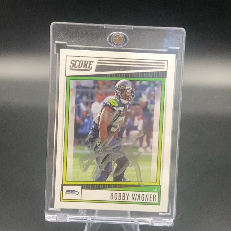 Rare - Live INK Card Autograph Score Bobby Wagner: RARE - Live INK Score football card featuring Seattle Seahawks linebacker Bobby Wagner. The card includes an autograph across the player image and is protected in a clear one touch magnetic plastic