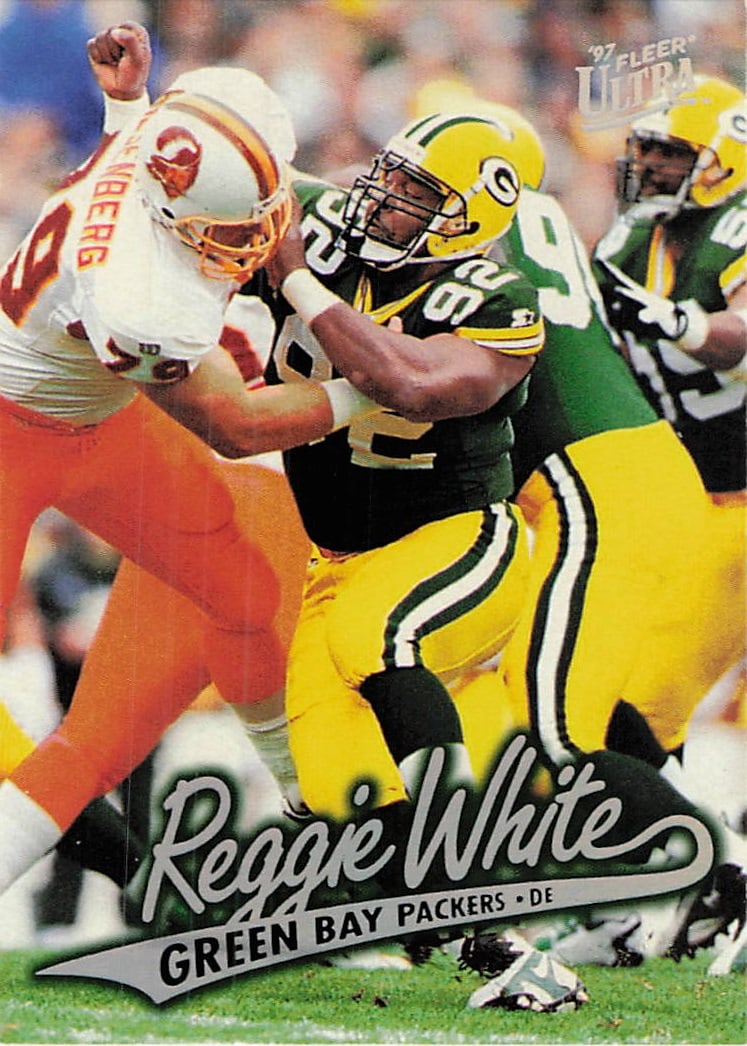 1997 Fleer Ultra Reggie White Green Bay Packers Card: This is a 1997 Fleer Ultra trading card featuring NFL Hall of Famer Reggie White of the Green Bay Packers. The card showcases a dynamic action photograph of the legendary defensive end in his Packers