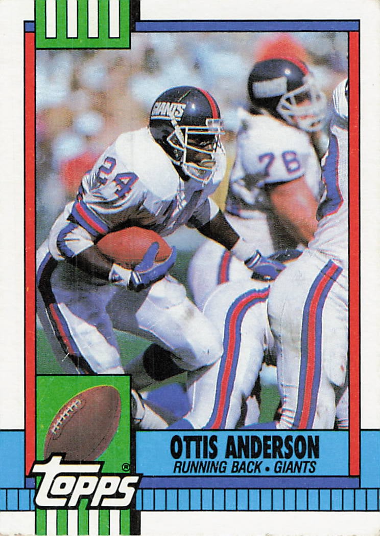 1990 Topps Ottis Anderson New York Giants Football Card: This is a 1990 Topps football card featuring running back Ottis Anderson of the New York Giants, card number 220. The card depicts Anderson in action, carrying the ball while navigating through
