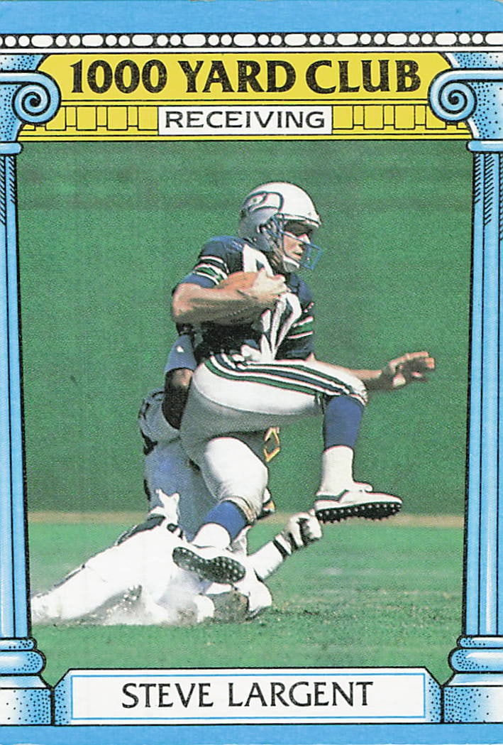 1986 Topps Steve Largent Seattle Seahawks Card: This is a 1986 Topps football card featuring Hall of Fame wide receiver Steve Largent of the Seattle Seahawks, card number 375. The card is from the '1000 Yard Club' subset, highlighting his