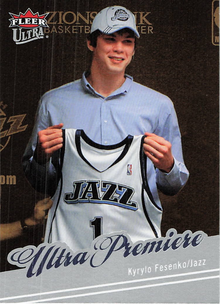 2007-08 Fleer Ultra Kyrylo Fesenko Ultra Premiere RC: This is a 2007-08 Fleer Ultra basketball trading card featuring Kyrylo Fesenko of the Utah Jazz. The card is part of the 'Ultra Premiere' insert set and shows Fesenko holding up his team jersey upon