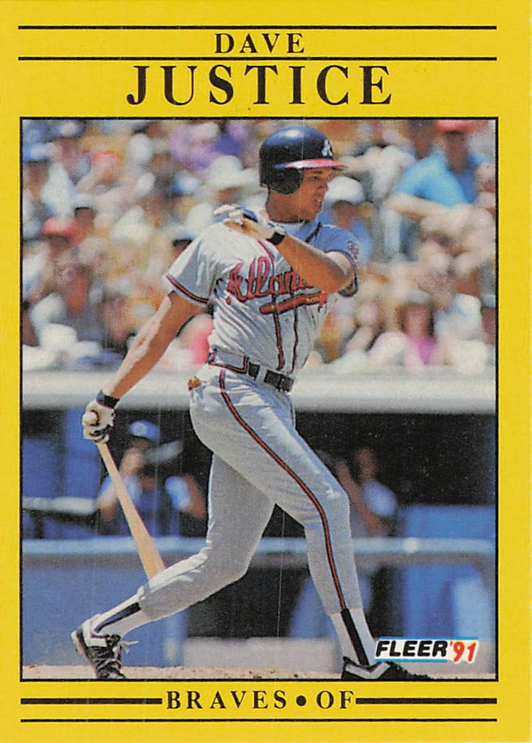 1991 Fleer David Justice Atlanta Braves Baseball Card: This is a 1991 Fleer baseball card featuring Atlanta Braves outfielder David Justice. The card showcases Justice in a batting stance, wearing his grey road uniform. This card is part of the 1991