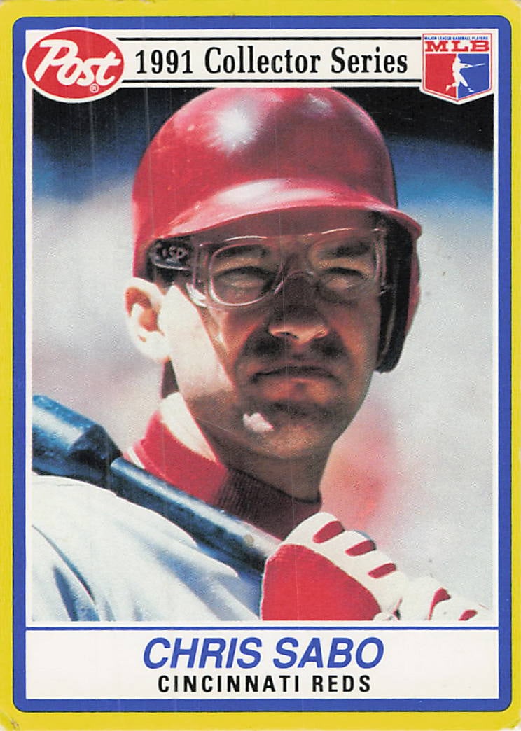 1991 Post Cereal Chris Sabo Cincinnati Reds Trading Card: This is a 1991 Post Cereal Collector Series trading card featuring Chris Sabo of the Cincinnati Reds. The card captures a close-up portrait of the player wearing his iconic sports goggles while