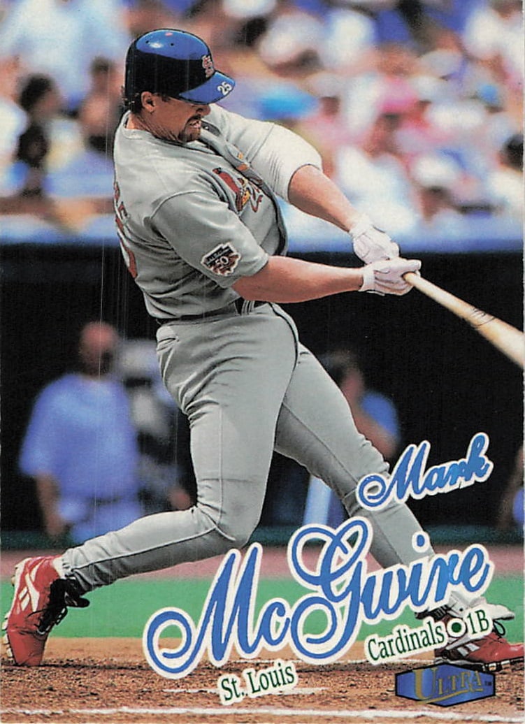 1999 Fleer Ultra Mark McGwire St. Louis Cardinals Card: This is a 1999 Fleer Ultra baseball card featuring Mark McGwire of the St. Louis Cardinals. The card captures McGwire in his follow-through swing motion, wearing his gray road uniform with the