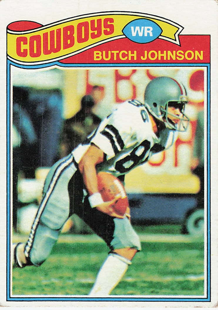 1977 Topps Butch Johnson Dallas Cowboys Football Card: This is a 1977 Topps football card featuring Dallas Cowboys wide receiver Butch Johnson. The card displays the iconic 1977 design with the team name displayed in a large ribbon at the top and the
