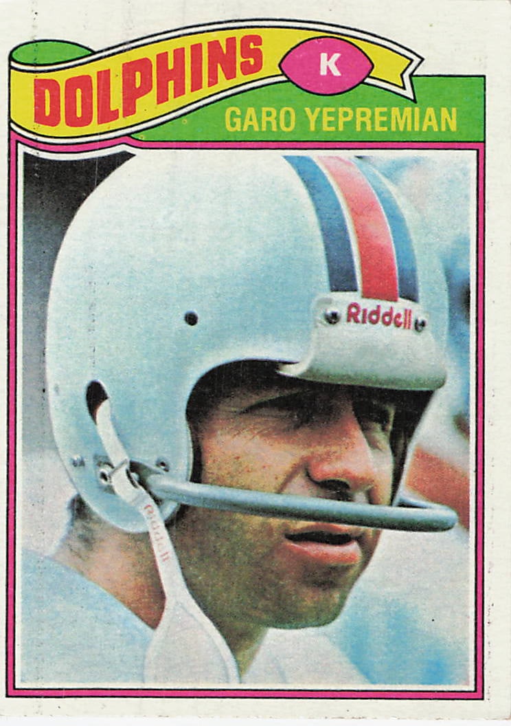 1977 Topps Garo Yepremian Miami Dolphins Football Card: This is a 1977 Topps Football card featuring kicker Garo Yepremian of the Miami Dolphins. The card showcases a classic close-up portrait of Yepremian wearing his team helmet, a signature style for
