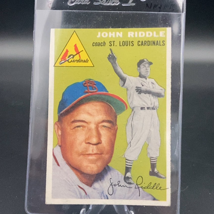 1954 Topps baseball trading card featuring St. Louis Cardinals coach John Riddle: This is a vintage baseball card featuring John Riddle, a coach for the St. Louis Cardinals. The card includes a portrait and a full-body action pose of the coach with the Cardinals team logo in the co