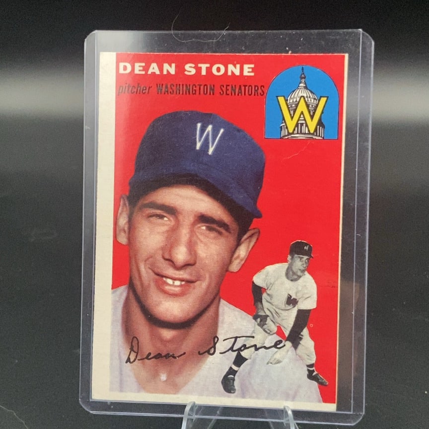 1954 Topps #114 Dean Stone vintage baseball card: This is a vintage baseball card featuring pitcher Dean Stone of the Washington Senators. The card displays a red background, a portrait, and an action pose, along with a team logo depicting the U.S.