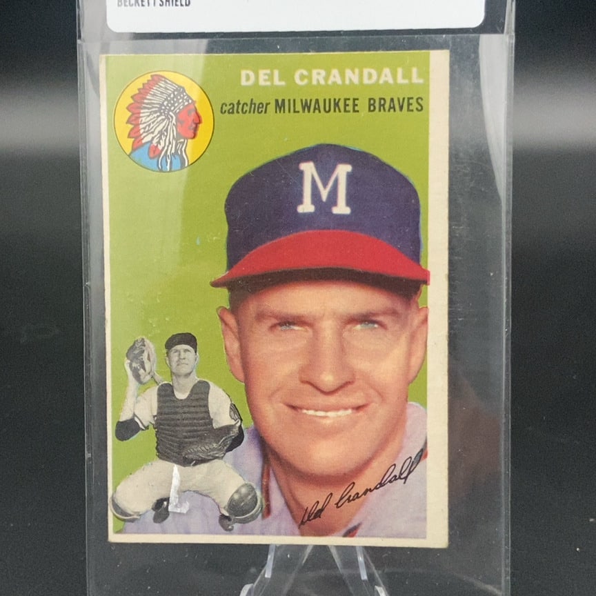 1954 Topps #12 Del Crandall baseball card: This is a 1954 Topps baseball card featuring Milwaukee Braves catcher Del Crandall. The card includes a close-up portrait, an action pose, and the player's printed autograph on the front. It is