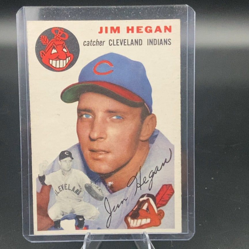 1954 Topps #29 Jim Hegan baseball card: This is a vintage baseball card featuring Jim Hegan of the Cleveland Indians. The card displays his portrait along with a small action shot of him in his catcher gear, accompanied by an