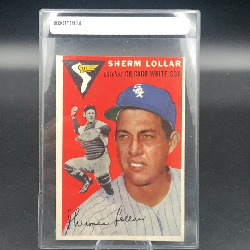 1954 Topps #39 Sherm Lollar baseball card: This is a vintage trading card featuring Sherm Lollar of the Chicago White Sox. The card showcases both a portrait and an action image of the catcher set against a vibrant red background. It is